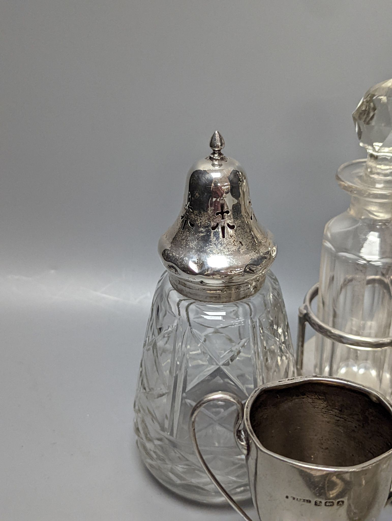 A plated cruet stand, two cased sets of silver handled tea knives, a silver domed ashtray(a.f.) silver trophy cup, four silver mounted glass jars and a plated napkin ring.